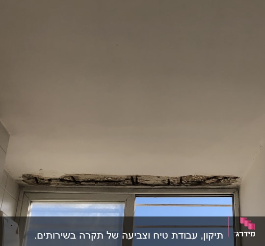 תקרה עם קילופי צבע מעל חלון